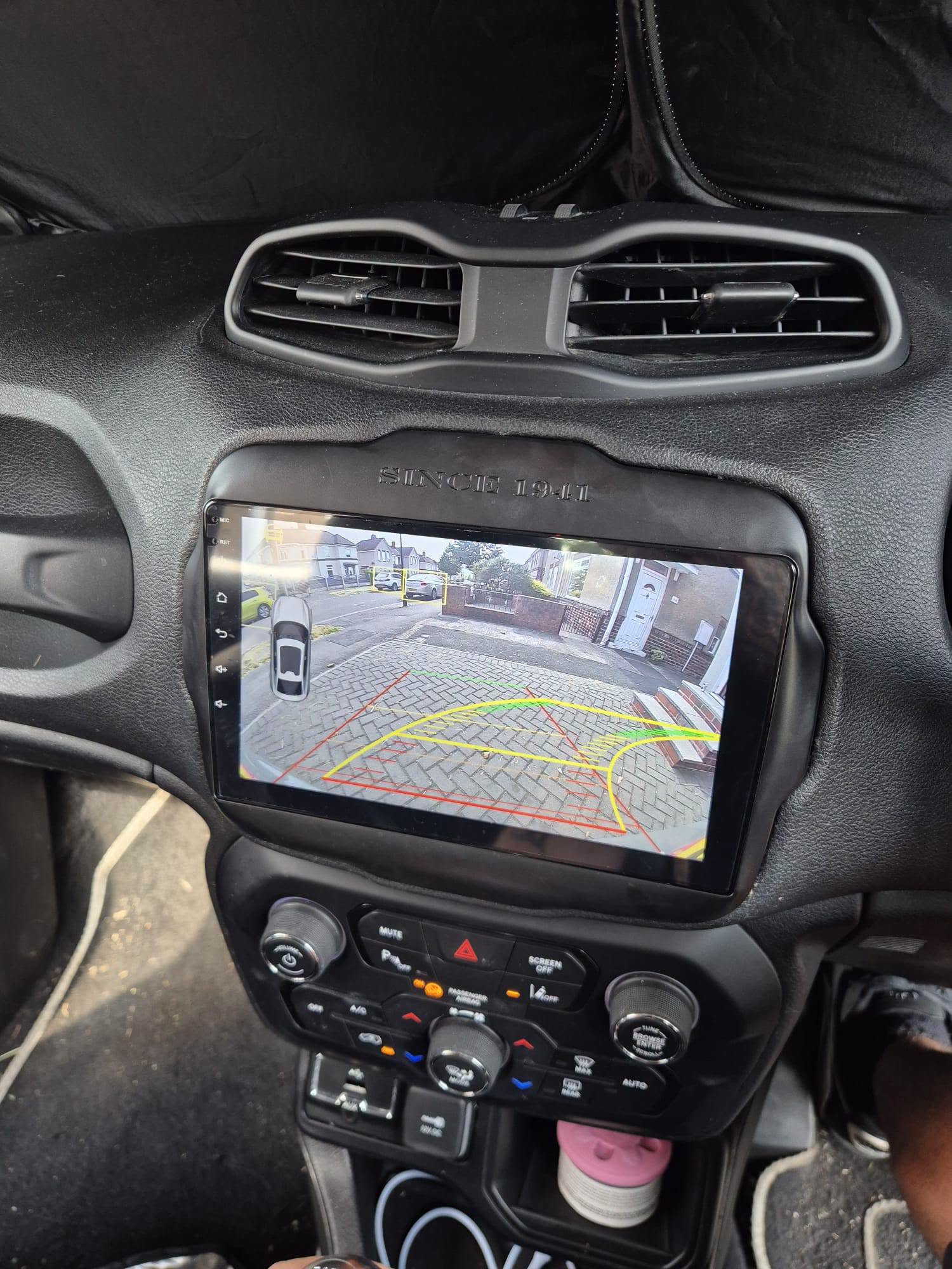 Car stereo screen showing a reversing camera view with parking guidelines
